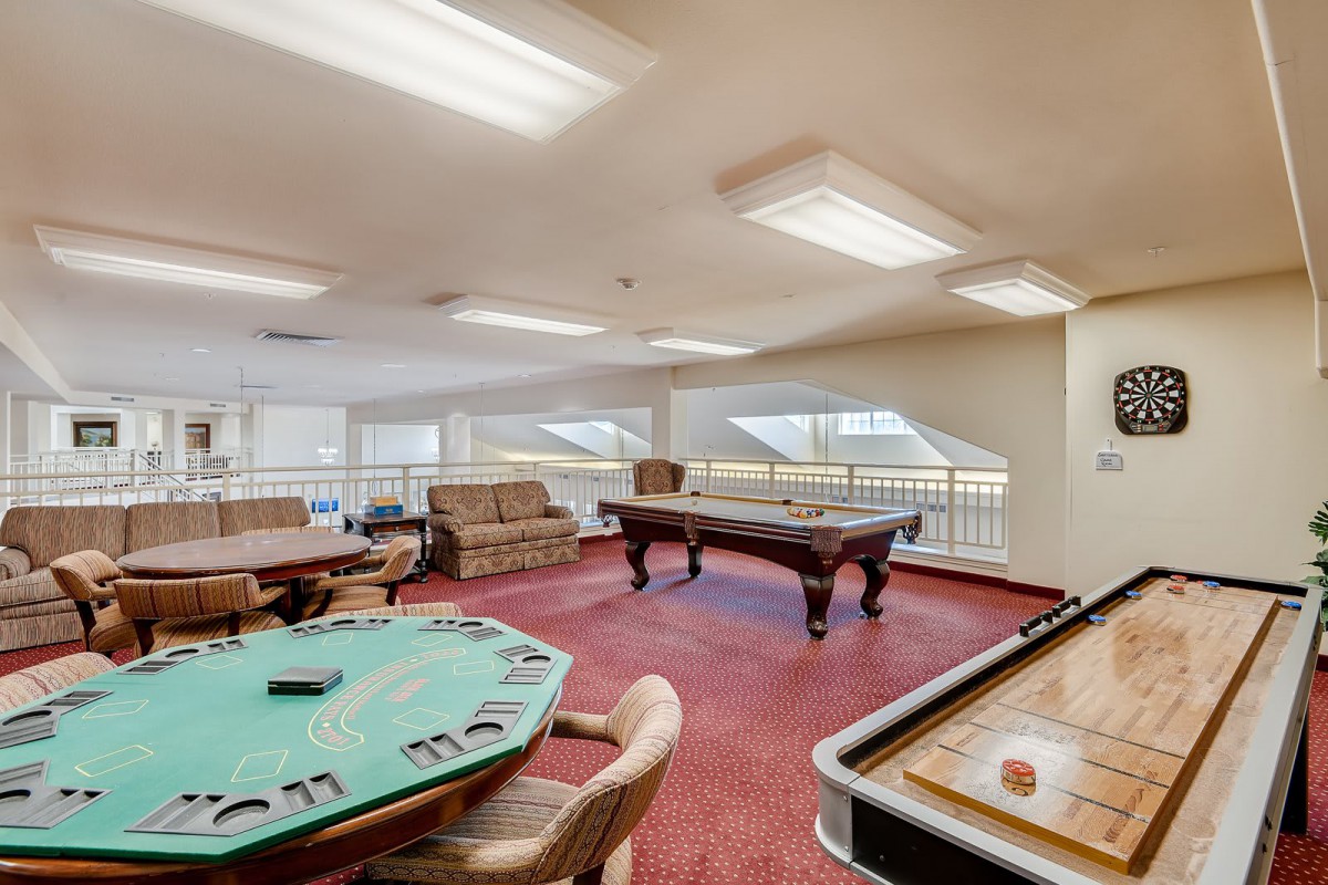 A well-equipped game room featuring a pool table, casino table, and shuffleboard.