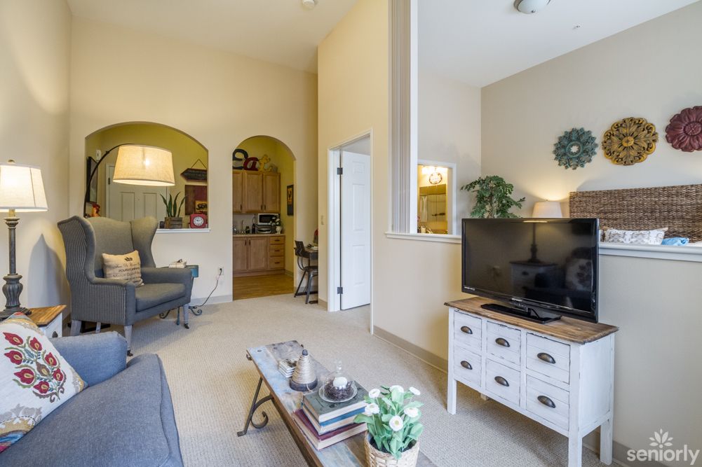 A cozy living room with a television, sofa, and stylish decor creating a warm atmosphere.