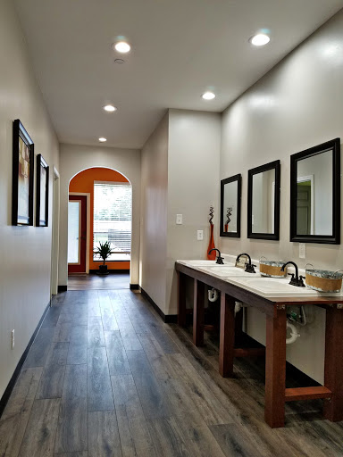 A modern bathroom hallway featuring dual sinks, stylish mirrors, and elegant lighting.