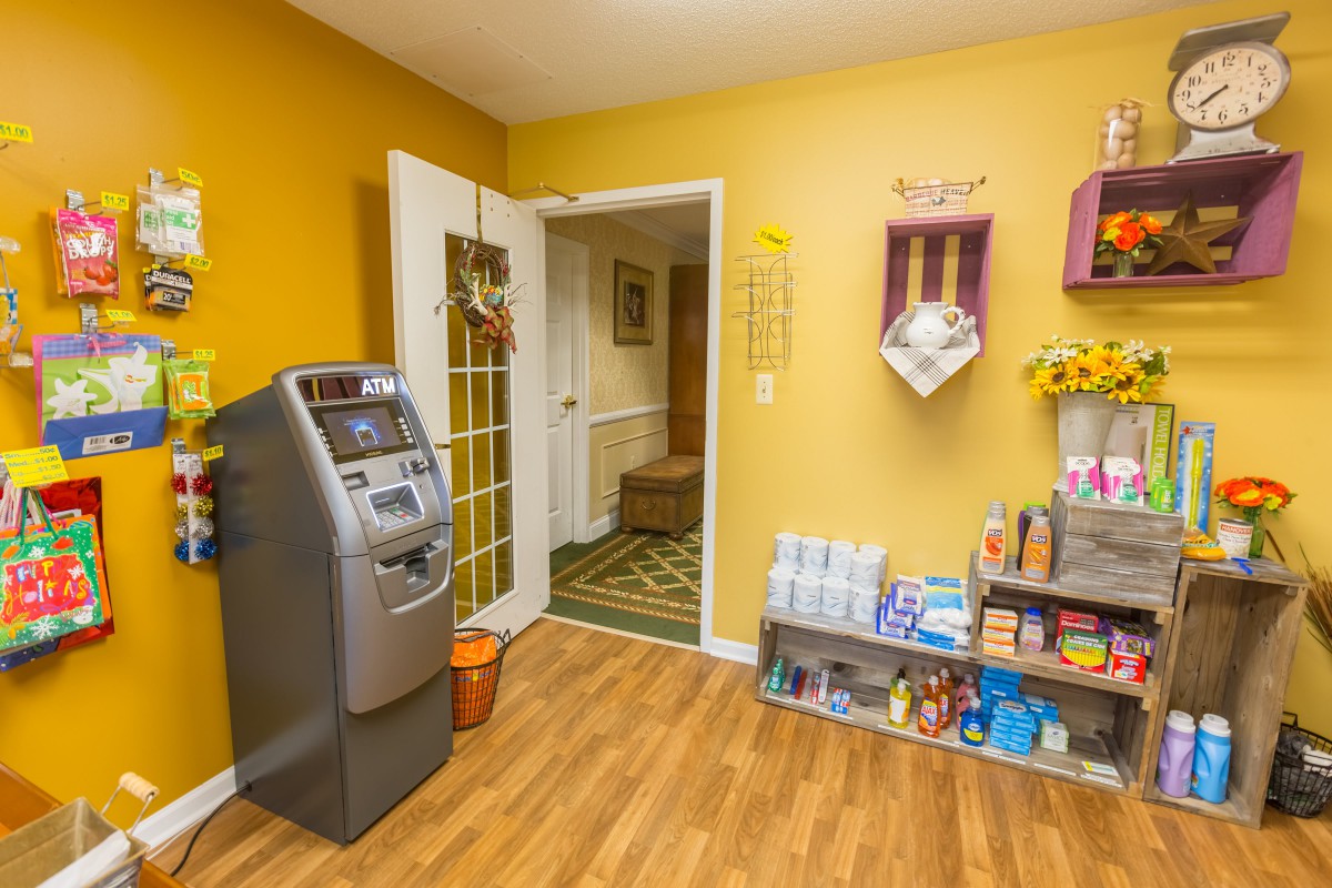 A cozy indoor waiting area with an ATM and magazine display.