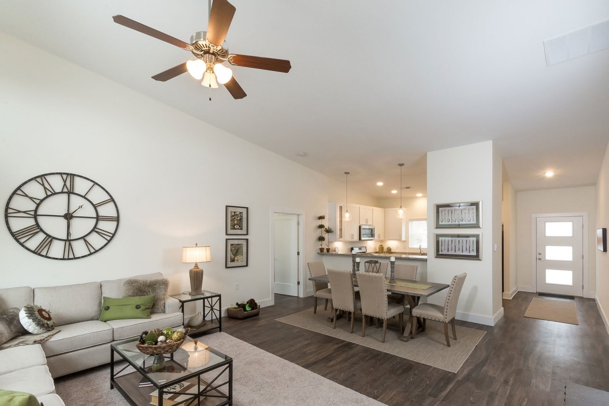 A modern open-concept living and dining area featuring neutral tones and sleek furnishings.