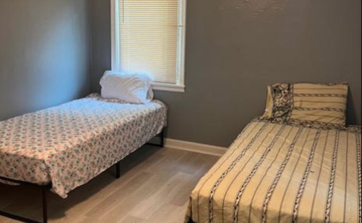 A minimalist bedroom with two twin beds and simple decor.