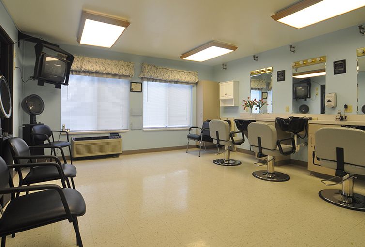 A well-lit salon interior with styling chairs and a waiting area.