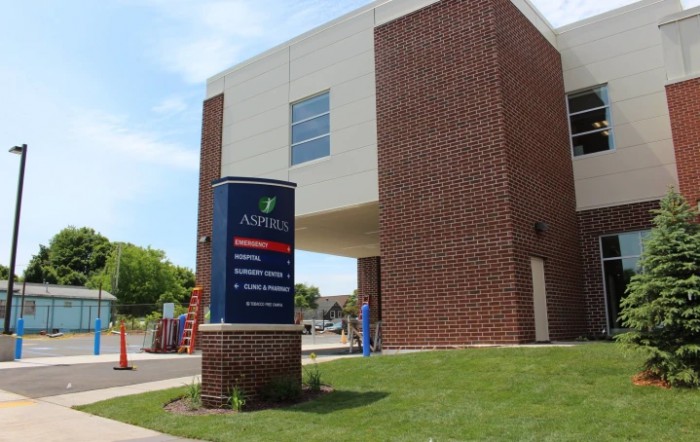 A modern hospital building with a prominent entrance and signage.