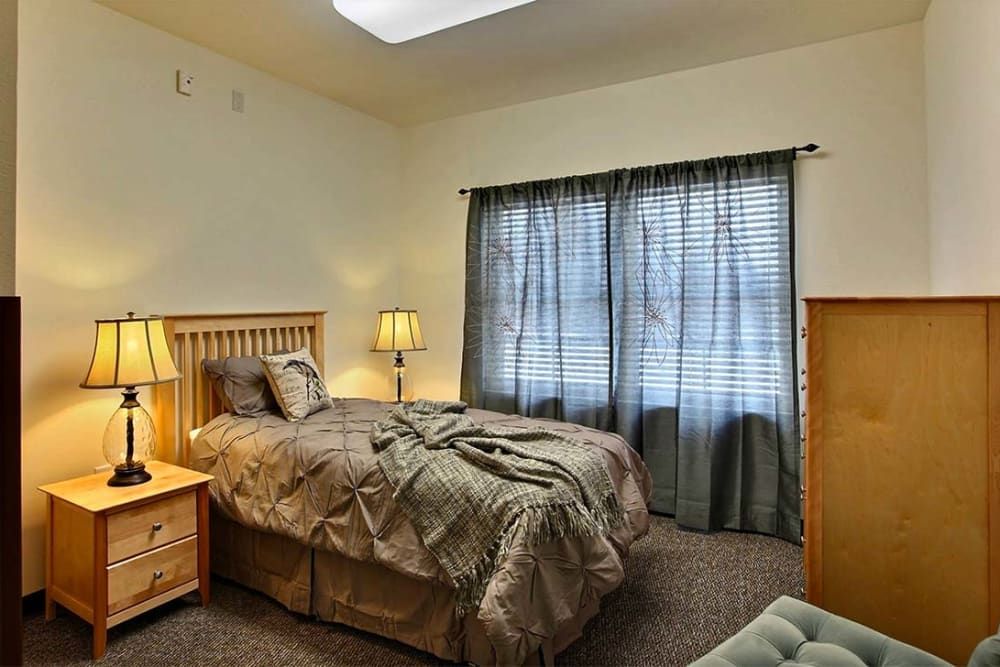 A cozy bedroom with a large bed, wooden furniture, and soft lighting.