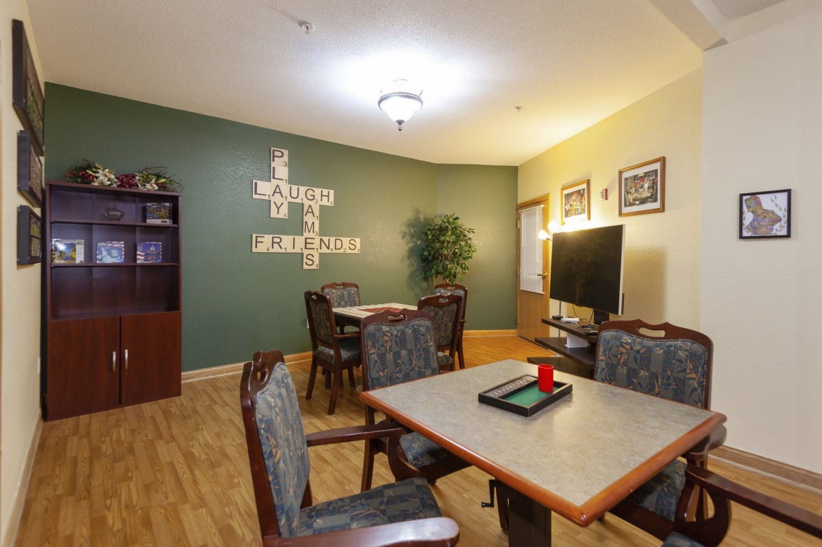 A cozy living area with dining tables, a TV, and decorative elements.