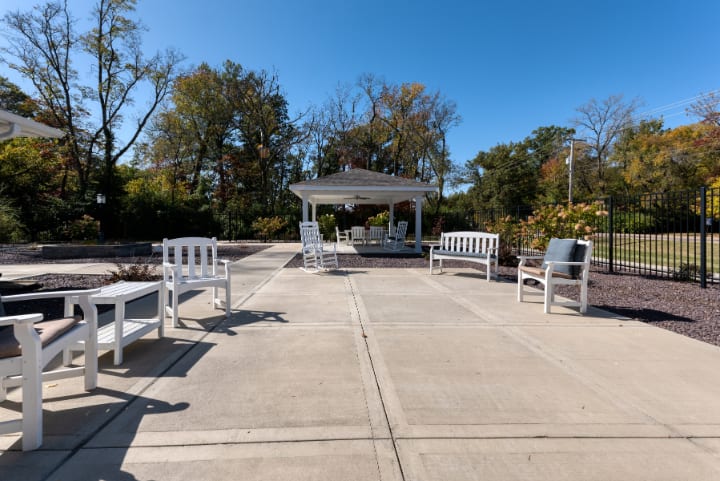 A tranquil park setting with a gazebo and benches on a sunny day.