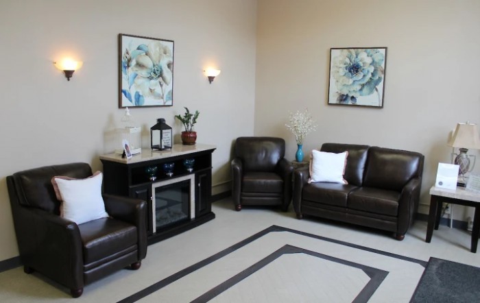 A cozy living room with leather furniture and decorative artwork on the walls.