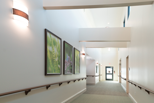 A well-lit hallway featuring framed artwork on the walls, adding a touch of elegance to the space.