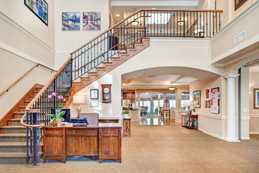 Spacious lobby area with a reception desk and staircase in a modern interior setting.