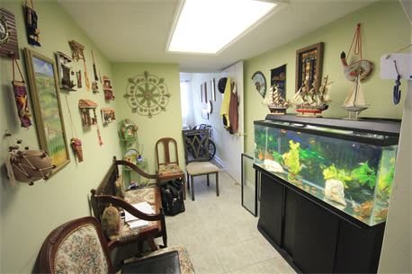 A cozy room with nautical-themed decor, featuring a large aquarium and vintage furniture.