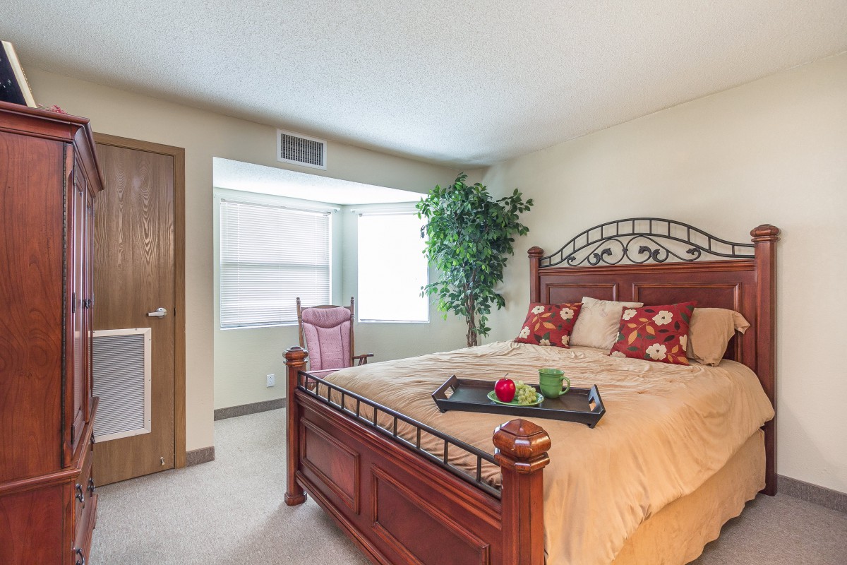 Cozy bedroom with a wooden bed and decorative elements.