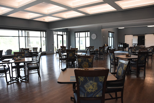 A spacious and well-lit dining area featuring modern furniture, suitable for community gatherings.