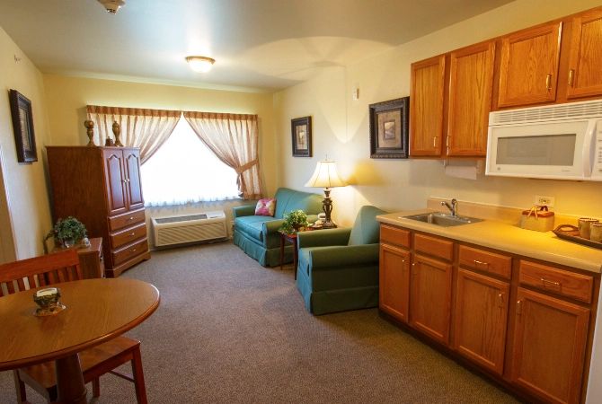 Cozy living area with a sofa, kitchenette, and large window.