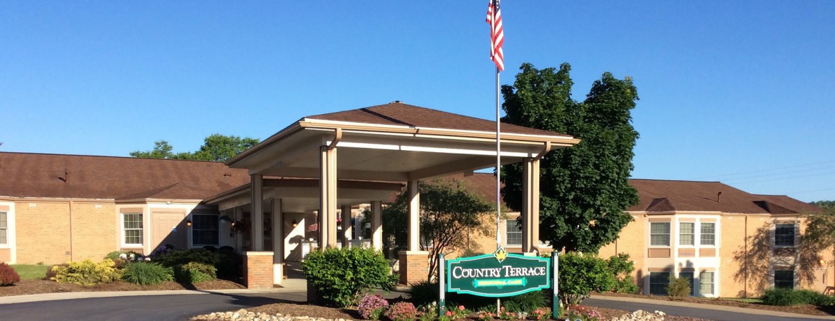 Entrance to a building with an American flag and a sign that reads 'Country Terrace'.