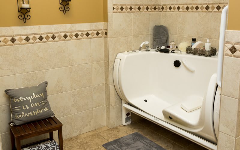 A well-decorated bathroom featuring a modern bathtub with decorative tiles and accessories.