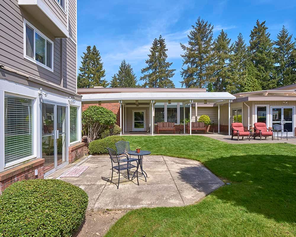 A spacious backyard patio with outdoor seating and a well-maintained lawn.
