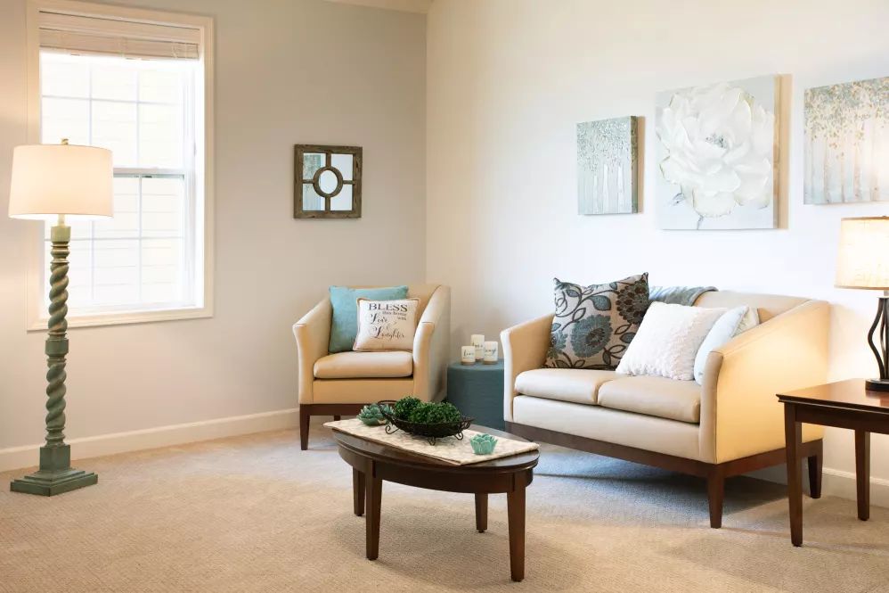 A cozy living room with a sofa, armchair, and coffee table, showcasing elegant home decor.