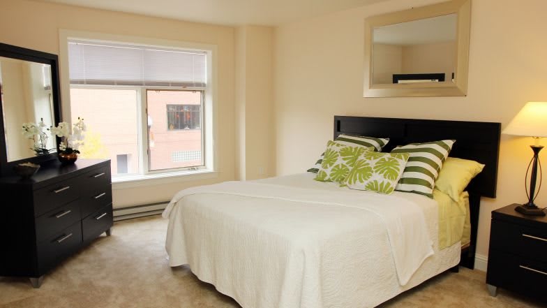 Minimalist bedroom with a cozy bed and large window.