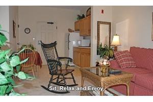 A cozy living area with a rocking chair and kitchenette, inviting you to sit, relax, and enjoy.
