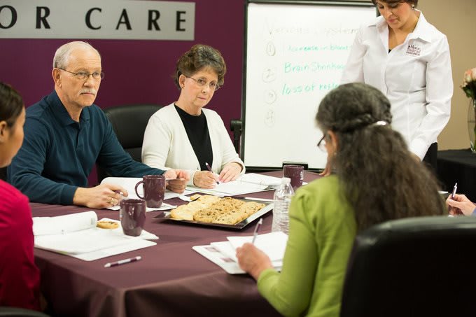 Group of people engaged in a business meeting around a conference table.