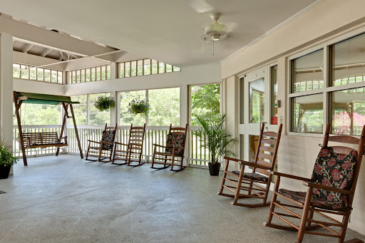 A serene outdoor porch featuring rocking chairs, perfect for relaxing in nature.