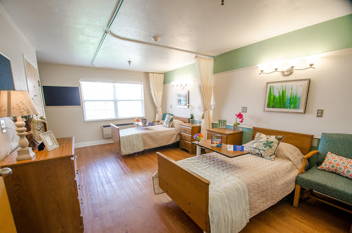 A well-lit hospital room with two patient beds and a welcoming atmosphere.