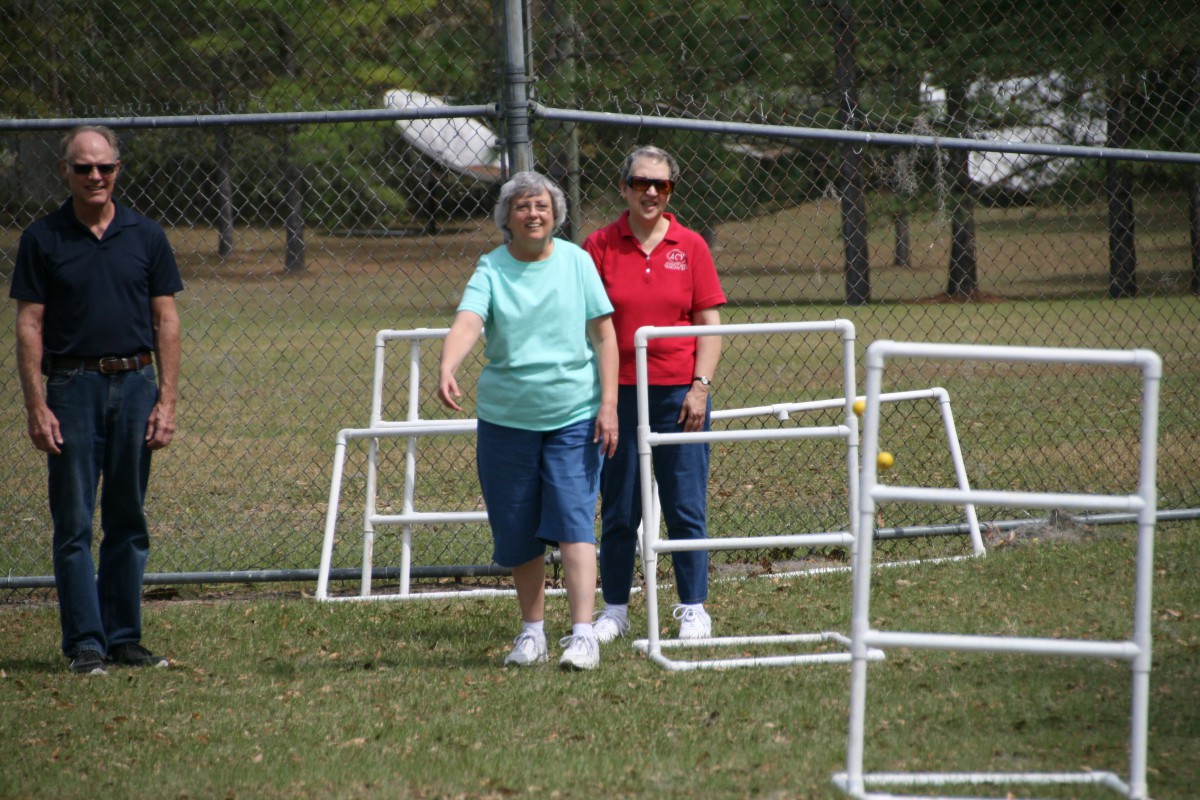 Two people walking near a fenced area in a park.