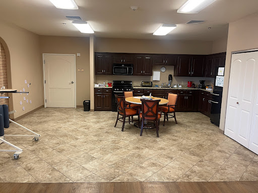 A modern kitchen and dining area featuring a table with orange chairs and contemporary appliances.