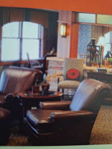A cozy living room setup featuring leather chairs and warm lighting.