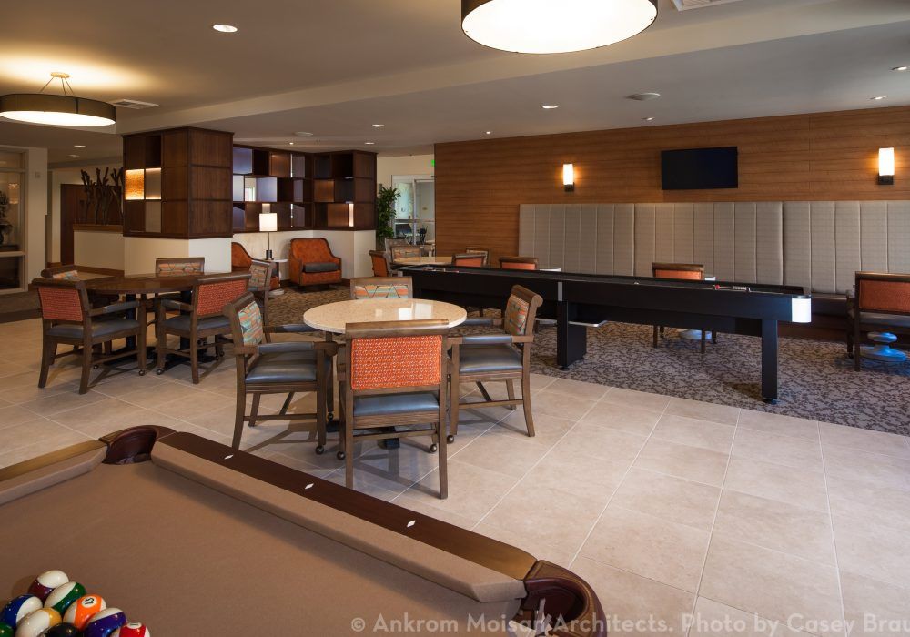 A modern game room featuring a pool table, seating area, and entertainment options.
