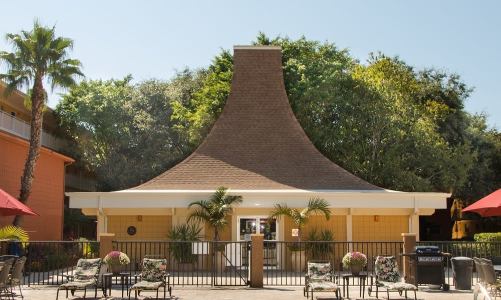 A uniquely designed building with a steep roof and an outdoor patio area surrounded by trees.