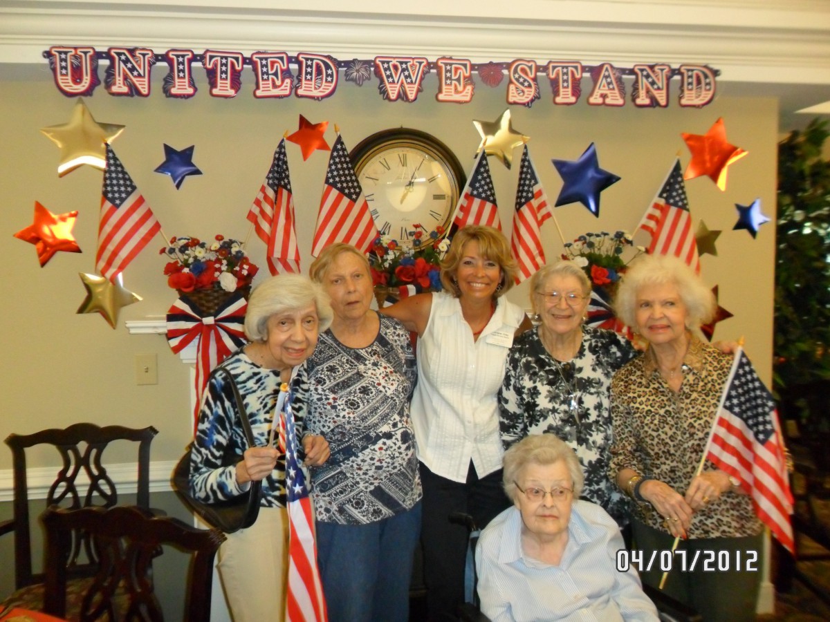 A group of people celebrating with American flags against a decorated backdrop.