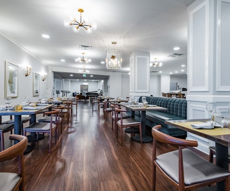 A modern and elegant restaurant interior with wooden floors, stylish furniture, and soft lighting.