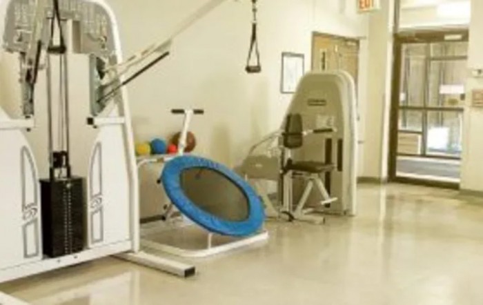 A gym area with various exercise machines and a small trampoline.