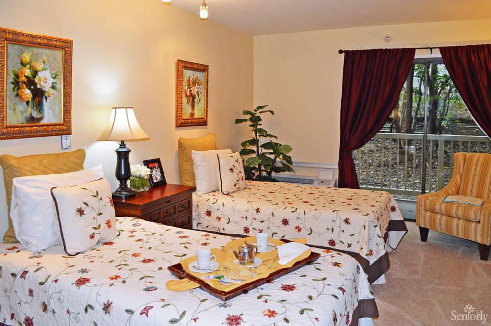 A cozy bedroom with twin beds, adorned with floral bedding and a welcoming tray.