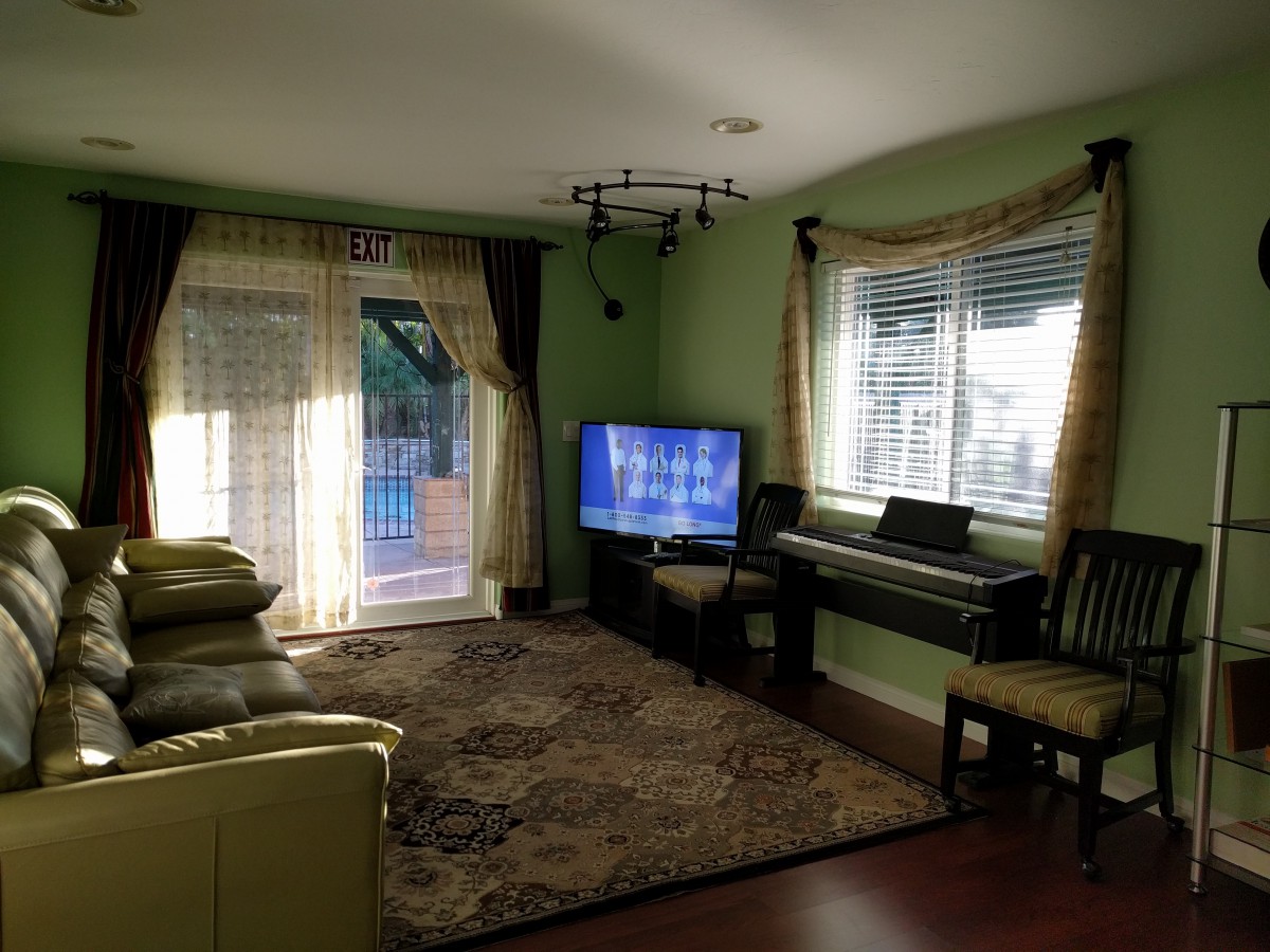 Cozy living room with a TV, piano, and comfortable seating.