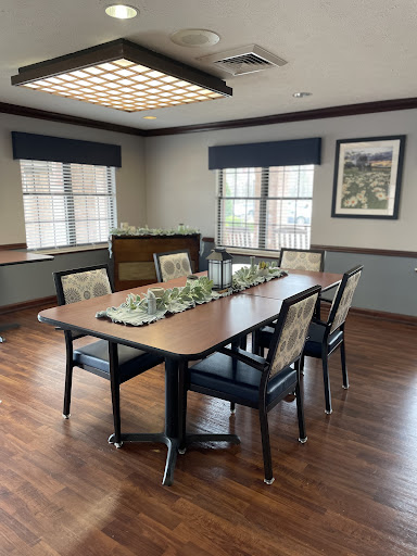 A well-lit conference room featuring a large table surrounded by chairs, perfect for meetings and discussions.
