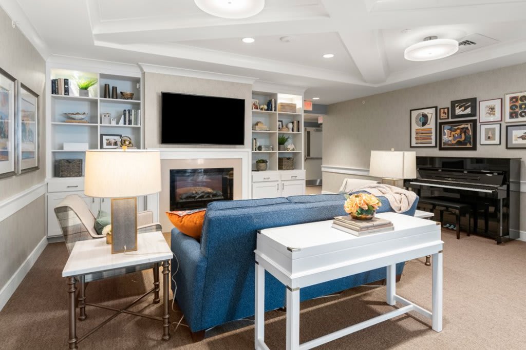 A modern living room with a cozy sofa, fireplace, and built-in bookshelves.