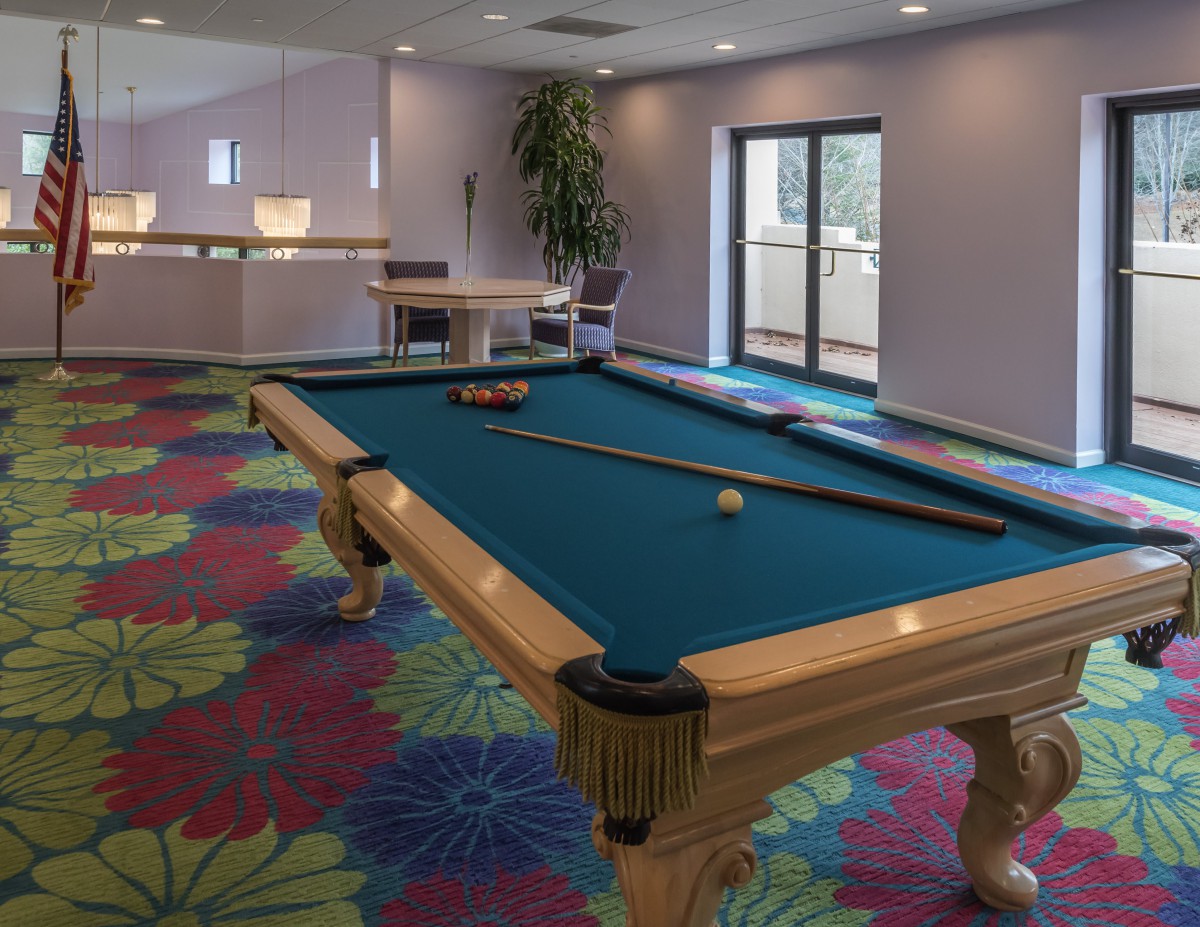 A game room featuring a pool table and colorful carpet.