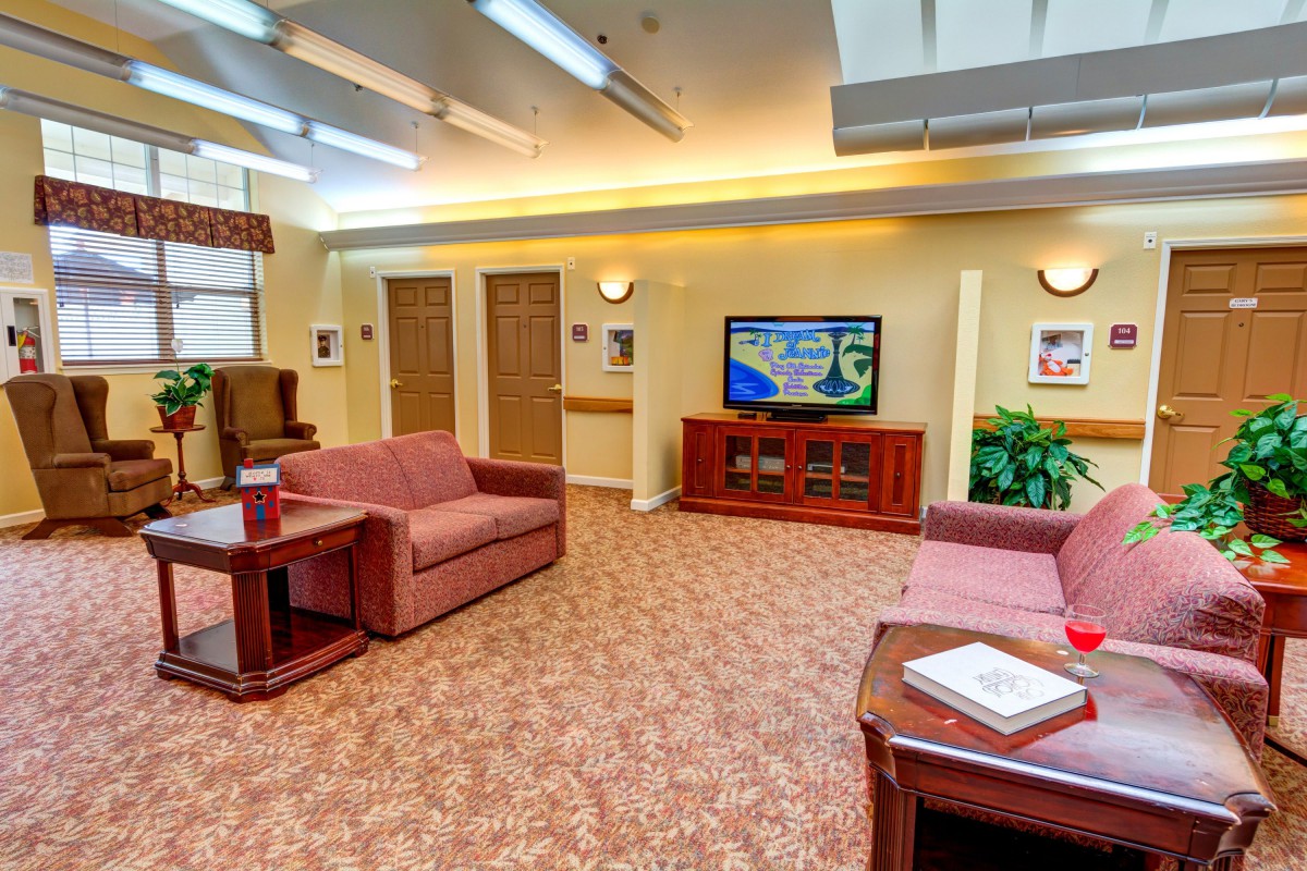 A cozy lobby area with sofas and a television, featuring warm lighting and decorative elements.
