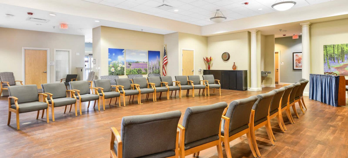 An empty waiting room with rows of chairs arranged neatly.