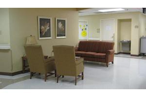 A cozy waiting room with comfortable chairs and a sofa.