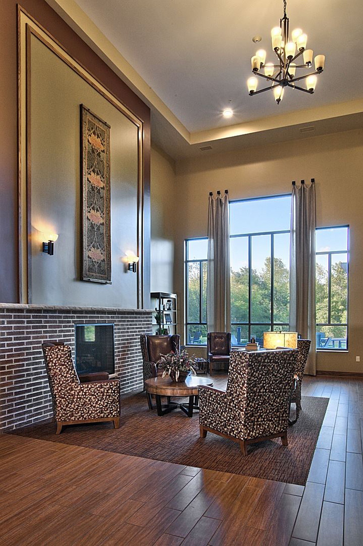 A modern living room with high ceilings, large windows, and stylish seating.