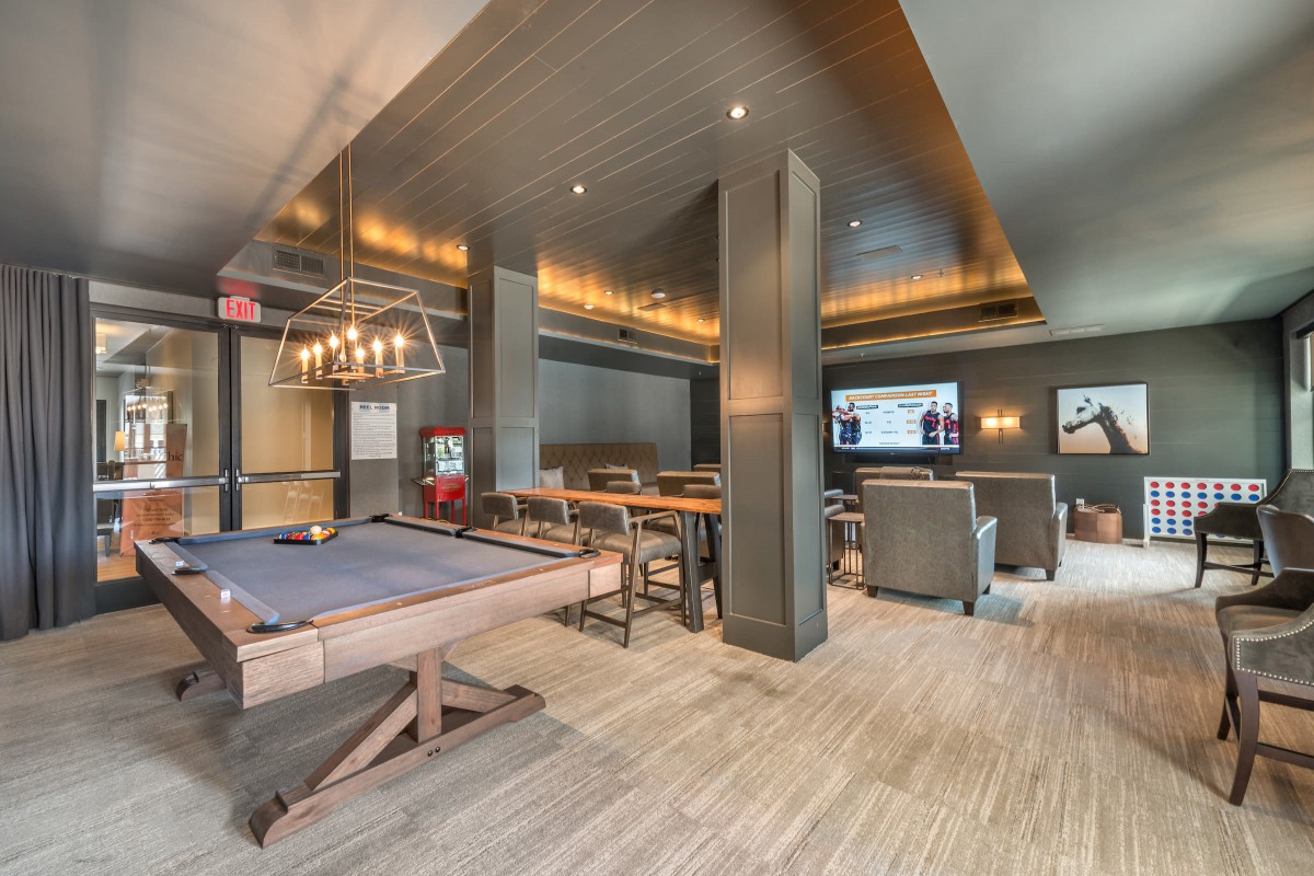 A luxurious lounge featuring a pool table, comfortable seating, and a large television.