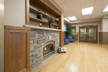 A cozy interior featuring a stone fireplace, wooden accents, and comfortable seating.