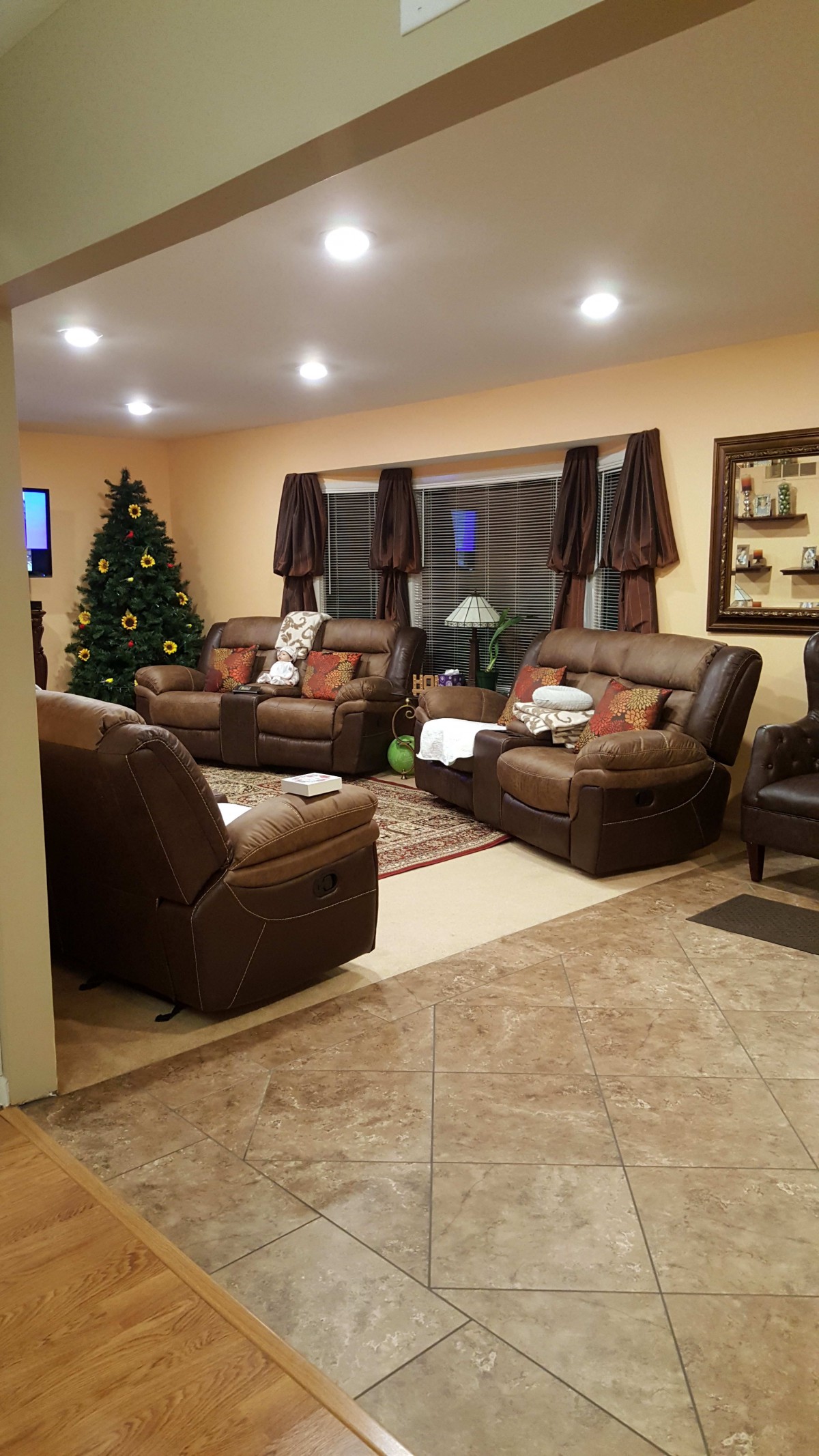 A cozy living room with leather sofas, a Christmas tree, and warm decor.