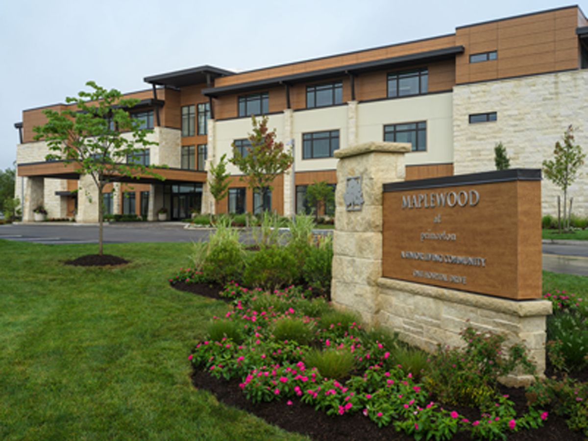 An exterior view of a modern building with well-maintained landscaping and a prominent entrance sign.