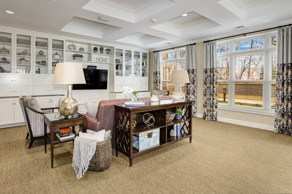 A modern and cozy living room featuring a stylish sofa, decorative shelves, and contemporary lighting.