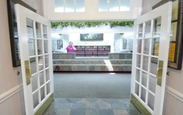 A spacious entrance with glass doors leading to a reception area.